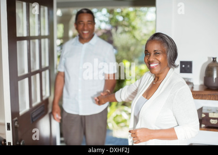 Porträt des Lächelns älteres Paar halten Hände in Tür Stockfoto
