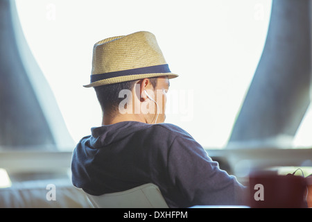 Mann in Fedora mit Kopfhörern Stockfoto