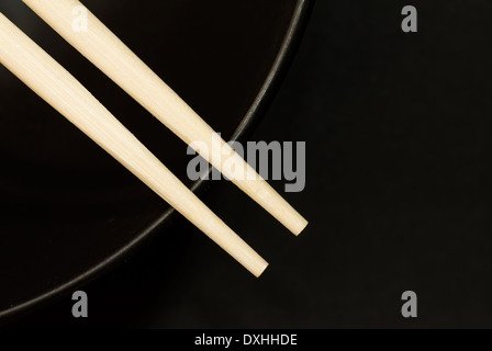 Zwei Stäbchen auf eine schwarze Schale Stockfoto