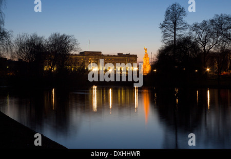 Buckingham Palace und Victoria Memorial spiegelt sich im See in St James Park in der Nacht Dämmerung Abenddämmerung London England UK Stockfoto