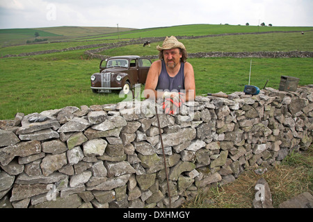 Mann Bau einer Trockensteinmauer im Peak District National Park, Derbyshire, England Stockfoto