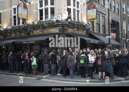 Trinker spill heraus auf der Straße vor dem Hund und Ente Pub in Soho, London, England Stockfoto