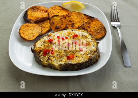 Horizontale Nahaufnahme Foto von gebackenem Fisch und Yam Scheiben auf weißen Teller mit Gabel und Tabelle Tuch unter Stockfoto