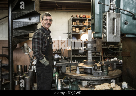 Porträt des kaukasischen Mann lächelnd in Metall-shop Stockfoto