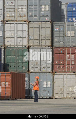 Arbeitnehmerin mit Zwischenablage in Cargo-Container terminal niedrigen Winkel Stockfoto