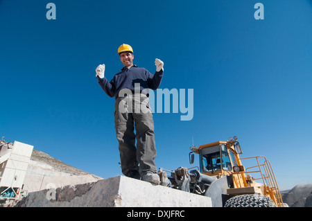 freudige Arbeiter auf Marmorplatte im Steinbruch Stockfoto