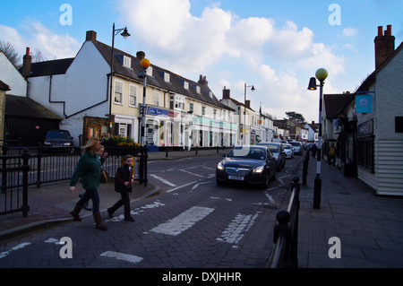 Eine Frau und jungen und Mädchen auf einem Fußgängerüberweg, bei Sonnenuntergang, Chipping Ongar, Essex, England Stockfoto