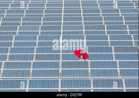Frau mit roten Regenschirm in solar-Kraftwerk Stockfoto
