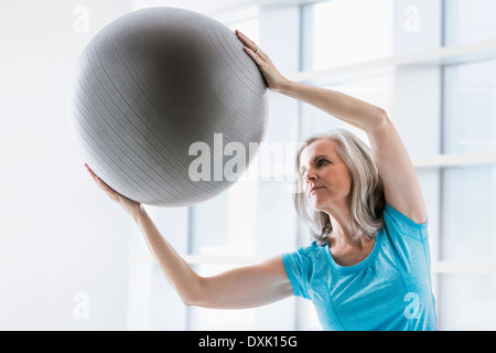 Kaukasische Frau lehnt sich mit Fitness-ball Stockfoto