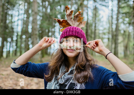 Porträt des kaukasischen Frau spielt mit Blättern Stockfoto