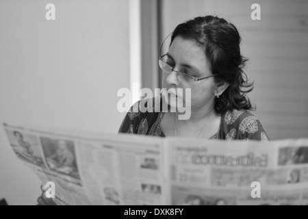 Frau liest Zeitung Stockfoto