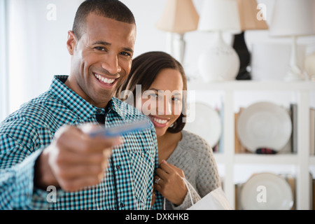 Porträt des glücklichen Paares, die Zahlung mit Kreditkarte im store Stockfoto