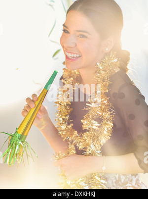 Lächelnde Hispanic Frau feiert Silvester Stockfoto