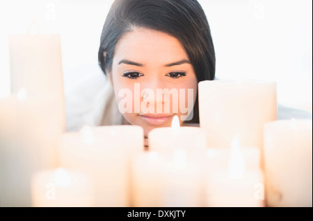 Hispanic Frau blickte auf Kerzen Stockfoto