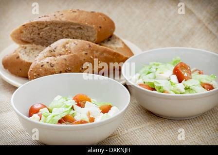 Zwei Fetta Salat Portionen und Scheiben Brot. Leckere Erfrischungen. Stockfoto