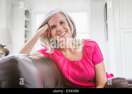 Porträt des Lächelns kaukasischen Frau auf sofa Stockfoto