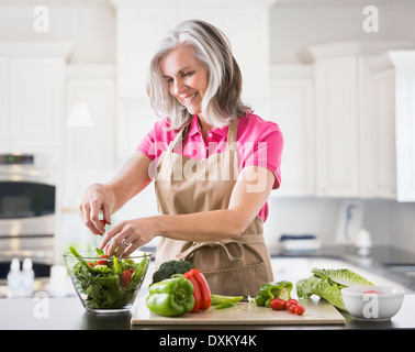 Kaukasische Frau bereitet Salat in Küche Stockfoto