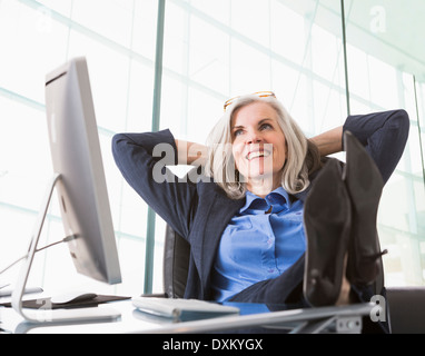 Zuversichtlich kaukasischen Geschäftsfrau mit Füße hoch auf Schreibtisch Stockfoto