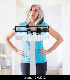 Kaukasische Frau Achselzucken auf Waage Stockfoto