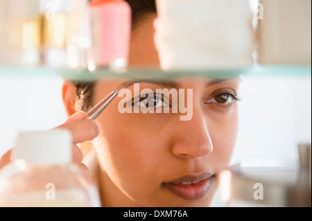 Nahaufnahme von Asiatin tweezing Augenbrauen Stockfoto