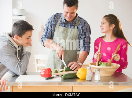 Kaukasische Vater und Kinder bereitet Salat in Küche Stockfoto