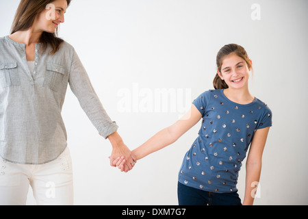 Porträt des Lächelns kaukasischen Tochter Hand in Hand mit Mutter Stockfoto