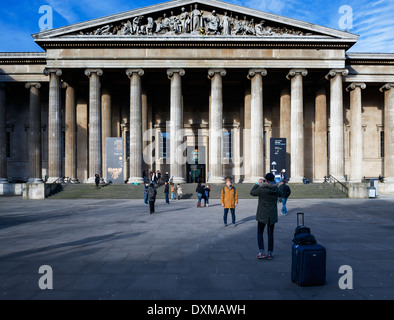 Ein Tourist stellt für sein Foto außerhalb des British Museum, London, UK Stockfoto