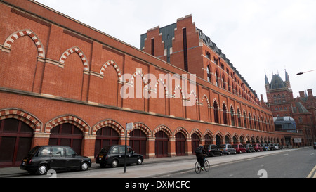 Person, die hinter dem Taxistand am Bahnhof St. Pancras in London, England UK KATHY DEWITT Radfahren Stockfoto