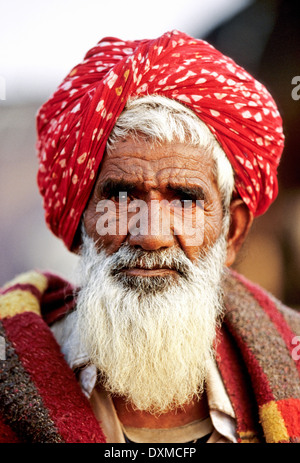 Porträt des alten indischen Mann mit grauem Bart mit roten Turban auf Pushkar Fair Kamel, Indien Stockfoto