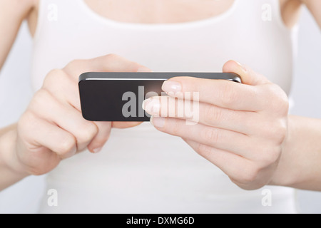 Nahaufnahme der Frau in weiß mit einem modernen smartphone Stockfoto