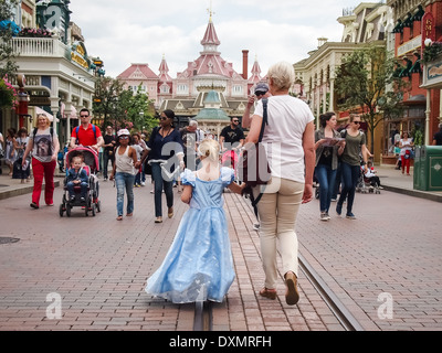 Kleines Mädchen, gekleidet in ein Disney Prinzessin Kostüm und weiblichen Erwachsenen spazieren entlang der Hauptstraße in Disneyland Paris, Frankreich Stockfoto