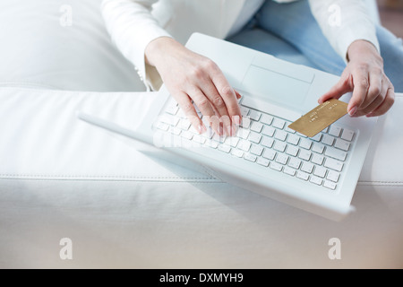 Händen der weiblichen sitzen am Laptop mit einer Kreditkarte Stockfoto