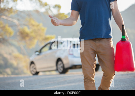 Mann mit Gas kann per Anhalter am Straßenrand Stockfoto