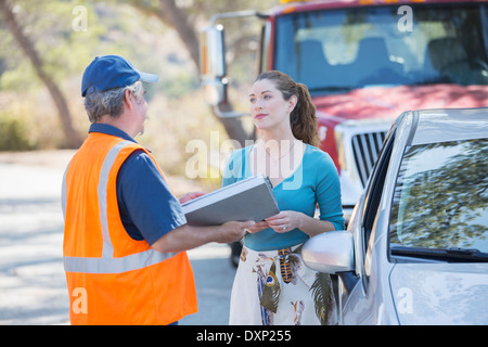 Am Straßenrand Mechaniker im Gespräch mit Frau Stockfoto