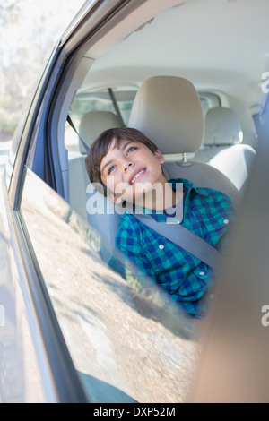 Fröhlicher Junge schaut aus dem Autofenster Stockfoto