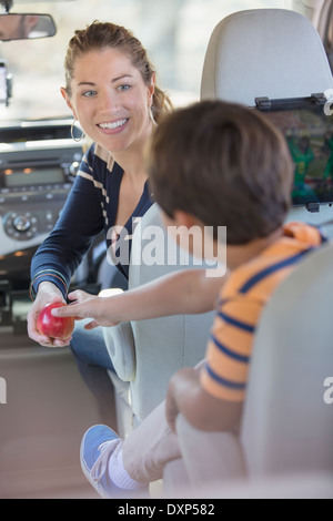 Mutter, junge einen Apfel in Auto Stockfoto