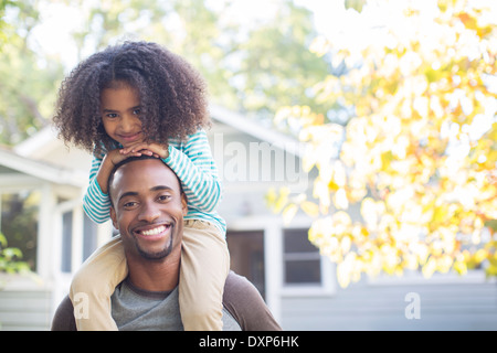 Porträt der glückliche Vater Tochter auf den Schultern tragen Stockfoto