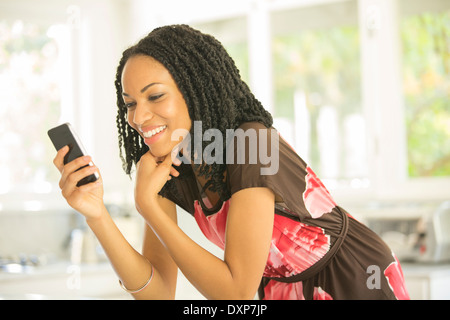 Glückliche Frau SMS mit Handy Stockfoto