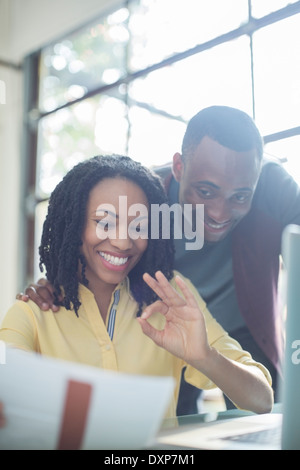 Glückliches Paar Lohnlisten am laptop Stockfoto