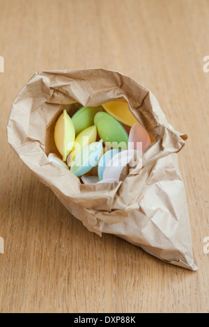 Ein zerknittertes Papier-Beutel gefüllt mit "fliegende Untertassen" sitzen auf einem Holztisch. Stockfoto