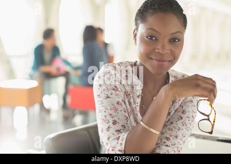 Porträt von zuversichtlich Geschäftsfrau hält Brillen Stockfoto