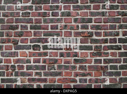 Alter, verwitterter Farbe gefärbten roten Backsteinmauer Stockfoto