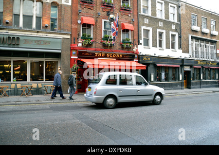 London Taxi vorbeifahren ein Restaurant & traditionelles englisches Pub in Bow Street London WC2 Stockfoto