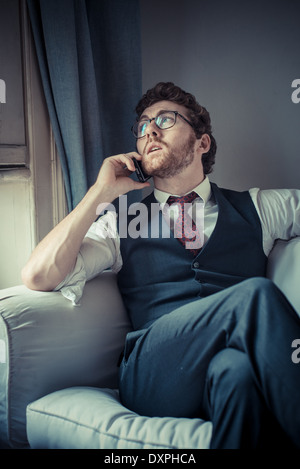 elegante attraktive Mode Hipster Mann am Telefon zu Hause Stockfoto