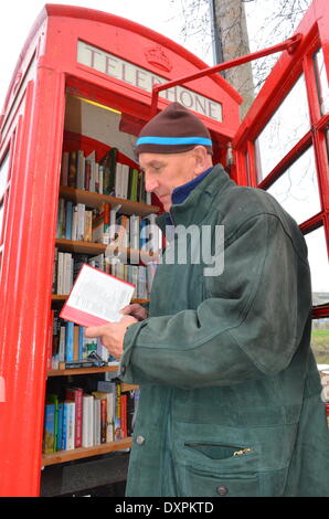 Burrowbridge, Somerset, UK. 28. März 2014. Eine vorübergehende Besucher Chris Williams gesehen ein Buch aus einer Telefonzelle rot UK verwandelte sich in eine Bibliothek am Burrowbridge in Somerset, die schweren Überschwemmungen das Dorf für einen Monat Credit geschlossen: Robert Timoney/Alamy Live News Stockfoto