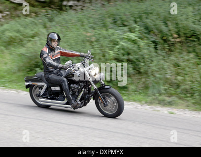 Kerl Reiten seine Harley Davidson mit Geschwindigkeit besitzen Cheddar Gorge, mit seinen Scheinwerfern auf Tagfahrlicht für Sicherheit und visability zeigen, September 2013 Stockfoto