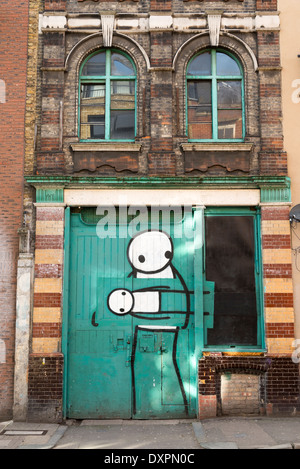 Graffiti von Stik an Tür in der Pitfields Straße in der Nähe von Old Street, Hoxton, London, England, UK Stockfoto