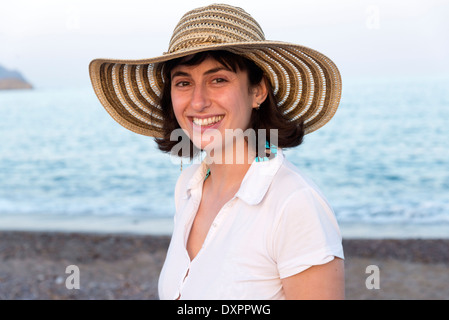 Junge Frau mit Strohhut am Meer Stockfoto