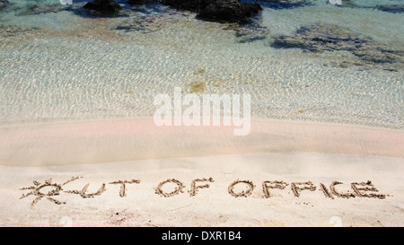 Aus dem Amt geschrieben am Sand an einem wunderschönen Strand blaue Wellen im Hintergrund Stockfoto