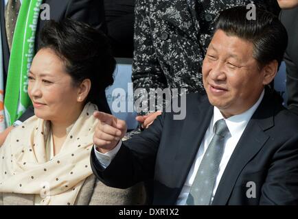 Berlin, Deutschland. 29. März 2014. Der chinesische Präsident und Generalsekretär der kommunistischen Partei Chinas, Xi Jinping (R) und seine Frau Peng Liyuan besuchen ein Freundschaftsspiel zwischen einer chinesische Jugend-Mannschaft und eine Jugend-Auswahl des Fußball-Bundesligisten VFL Wolfsburg mit einem T-shirt von Wolfsburg Bundesliga-Spieler im Olympiapark in Berlin, Deutschland, 29. März 2014 unterzeichnet. Es ist des ersten Staatsbesuchs in Deutschland von einem chinesischen Präsidenten seit acht Jahren. Foto: SOEREN STACHE/DPA/Alamy Live-Nachrichten Stockfoto